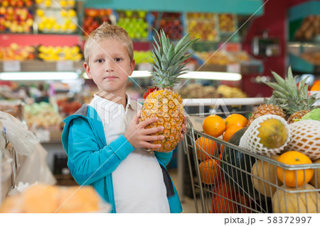 Kid holding big pineapple Kid holding big pineapple 58372997