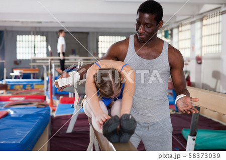 Nice African male coach helping teenage girl 58373039