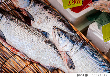 Whole fresh raw salmons on bamboo straw mat. 58374245