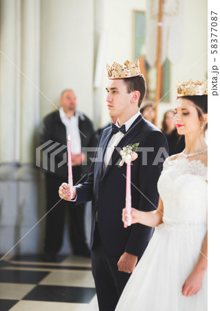 Bride and groom holding candles in church 58377087