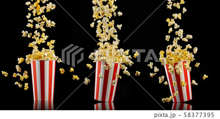 Set of paper striped buckets with popcorn isolated on black background Set of paper striped buckets with popcorn isolated on black background 58377395