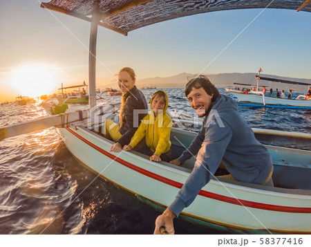 Happy family travelers meets dawn in the sea on a boat Happy family travelers meets dawn in the sea on a boat 58377416