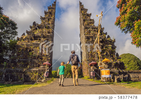 Father and son walking through Traditional Balinese Hindu gate Candi Bentar close to Bedugul, Bratan Father and son walking through Traditional Balinese Hindu gate Candi Bentar close to Bedugul, Bratan 58377478