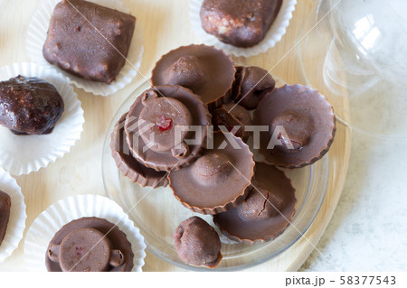 Homemade raw chocolate sweet candies with raspberries inside with droplets of water and raspberry Homemade raw chocolate sweet candies with raspberries inside with droplets of water and raspberry 58377543
