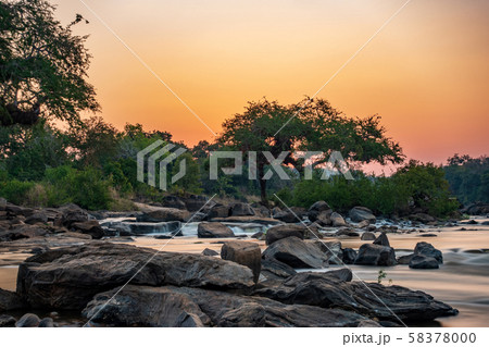 Sunset ultra long exposure with river, trees and rocks 58378000