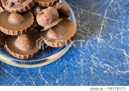 Homemade raw chocolate sweet candies with raspberries inside, Blue background with copy space 58378173