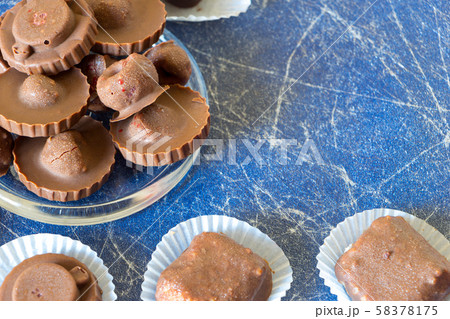 Homemade raw chocolate sweet candies with raspberries inside on Blue background with copy space 58378175
