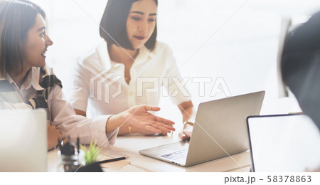 Two beautiful young asian businesswomen exchanging 58378863