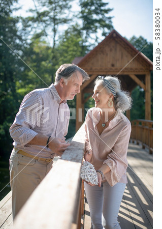 Grey-haired bearded man looking at his appealing lovely wife Grey-haired bearded man looking at his appealing lovely wife 58380034