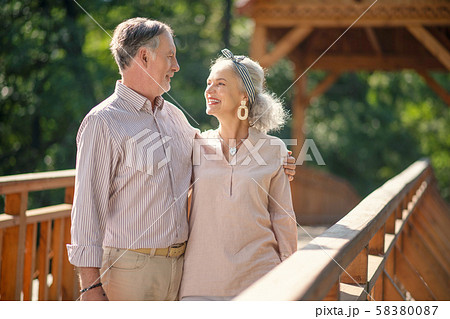 Grey-haired husband hugging his tender beautiful wife Grey-haired husband hugging his tender beautiful wife 58380087