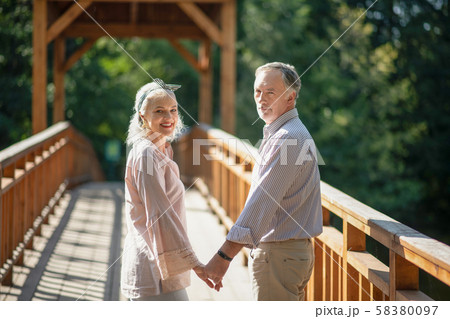 Couple walking hand in hand on the wooden bridge Couple walking hand in hand on the wooden bridge 58380097