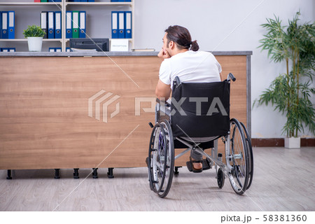 Young man at hospital reception desk Young man at hospital reception desk 58381360