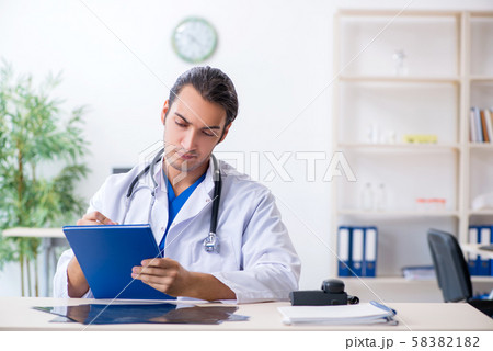 Young male doctor working in the clinic Young male doctor working in the clinic 58382182