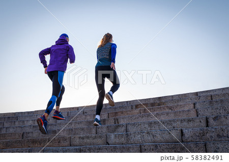 Sporty couple running up on the stairs Sporty couple running up on the stairs 58382491