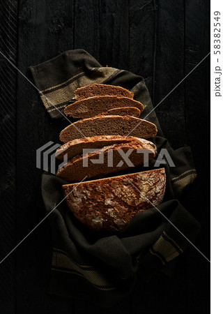 Sliced bread on black wooden background. 58382549