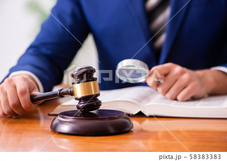 Young male judge sitting in courtroom 58383383