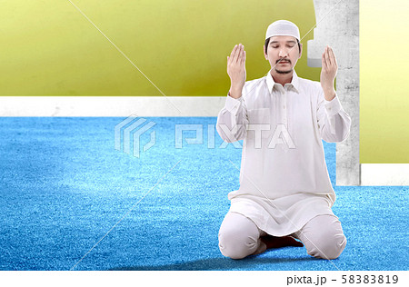 Asian Muslim man sitting in pray position Asian Muslim man sitting in pray position 58383819