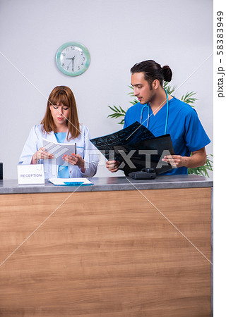 Two doctors working at the reception in the hospital Two doctors working at the reception in the hospital 58383949
