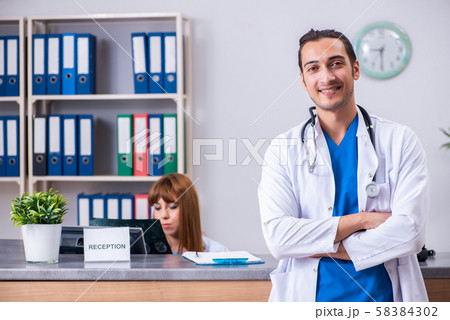 Two doctors working at the reception in the hospital Two doctors working at the reception in the hospital 58384302