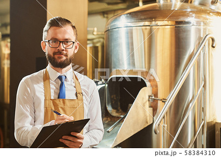 Expert of brewery holding folder, posing, looking at camera. 58384310