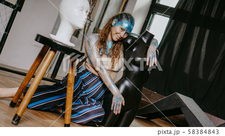 Long-haired beautiful artist in workshop with mannequins 58384843