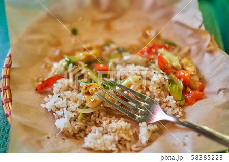 Fork, rice with vegetables on parchment in restaurant 58385223