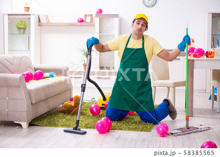 Young male contractor doing housework after party Young male contractor doing housework after party 58385565