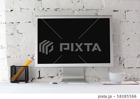 Mock up empty black monitor screen on white brick wall background 58385566