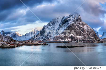 Lofoten island landscape, Norway. Mountain peak and ocean bay during sunrise. 58386246