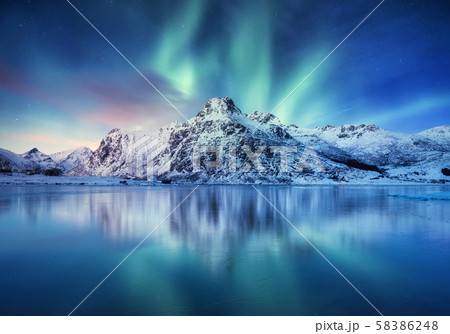 Aurora Borealis, Lofoten islands, Norway. Northen light, mountains and frozen ocean. 58386248