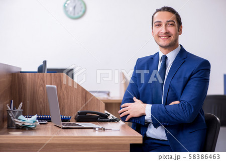 Young handsome businessman working in the office Young handsome businessman working in the office 58386463