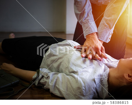 volunteer office man use hand pump on chest for first aid emergency CPR on heart attack woman unconscious, try to resuscitation patient woman at work volunteer office man use hand pump on chest for first aid emergency CPR on heart attack woman unconscious, try to resuscitation patient woman at work 58386815
