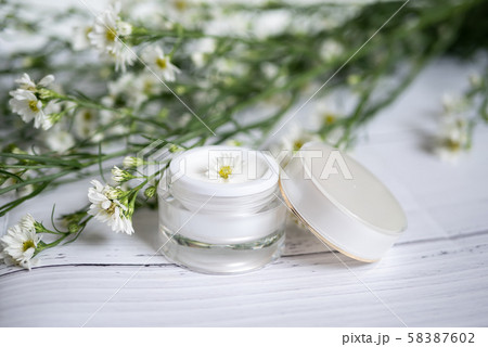 cosmetic nature skincare concept. organic natural beauty product. alternative medicine made from herbal. white cream serum in mock up packaging with blank label decorate with white flower cosmetic nature skincare concept. organic natural beauty product. alternative medicine made from herbal. white cream serum in mock up packaging with blank label decorate with white flower 58387602