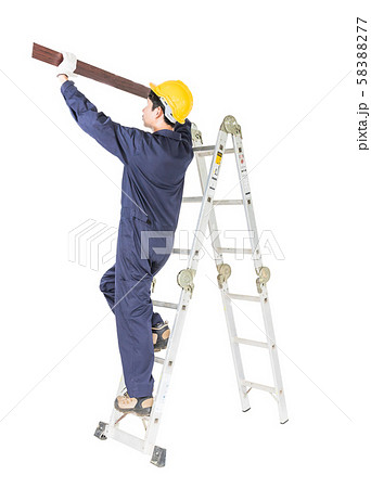 Handyman in uniform standing on ladder holding Handyman in uniform standing on ladder holding 58388277