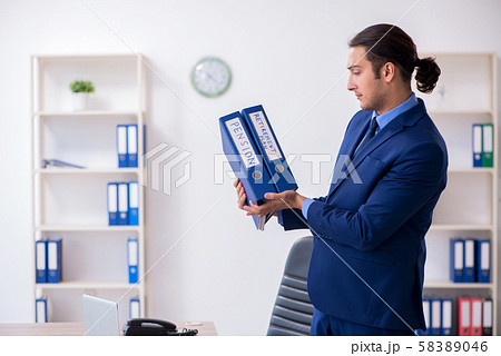 Young male accountant working in the office 58389046