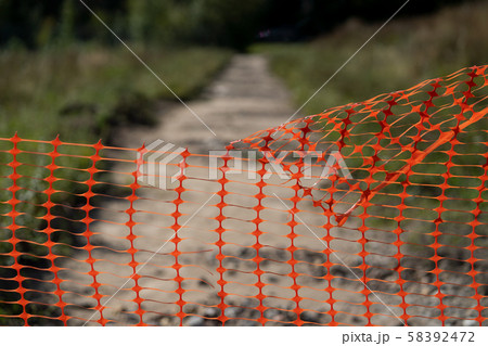 Perforated fence on a dirt road in autumn 58392472