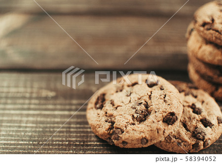 A stack of chocolate chip cookies lies on a wooden table. Rustic table. Vintage toning. Dietary A stack of chocolate chip cookies lies on a wooden table. Rustic table. Vintage toning. Dietary 58394052