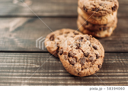 A stack of chocolate chip cookies lies on a wooden table. Rustic table. Vintage toning. Dietary A stack of chocolate chip cookies lies on a wooden table. Rustic table. Vintage toning. Dietary 58394060