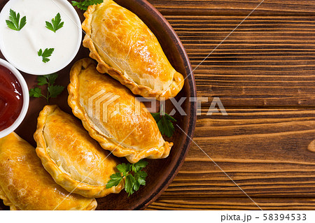 Latin American baked beef empanadas with sauce 58394533