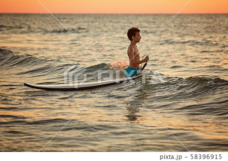Child surfing on tropical beach. Family summer vacation in Asia. Kids swim in ocean water Child surfing on tropical beach. Family summer vacation in Asia. Kids swim in ocean water 58396915