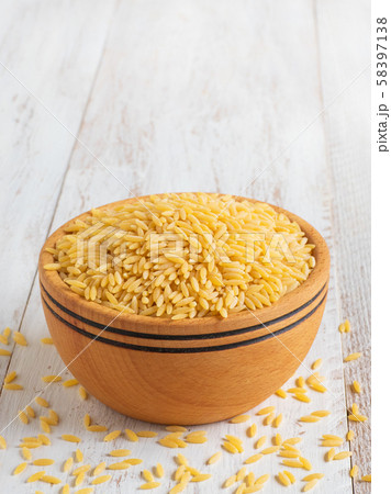 Raw orzo (risoni) pasta in wooden bowl. Close up 58397138