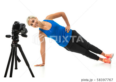The young sporty girl with a fair hair in a black sports topic, black leggings and bright sneakers The young sporty girl with a fair hair in a black sports topic, black leggings and bright sneakers 58397767