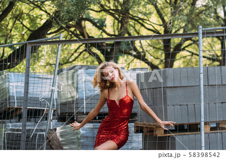 Beautiful girl with closed eyes in red short dress 58398542