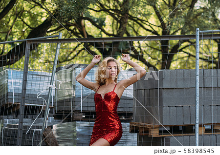 Beautiful girl with hands up in red short dress 58398545