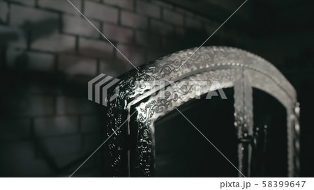 Forge workshop. Smithy manual production. A worker paints a part from a spray gun in black color 58399647