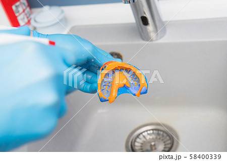 The dentist rinses the dental impression with 58400339