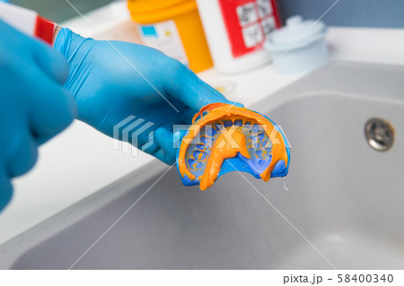 The dentist rinses the dental impression with 58400340