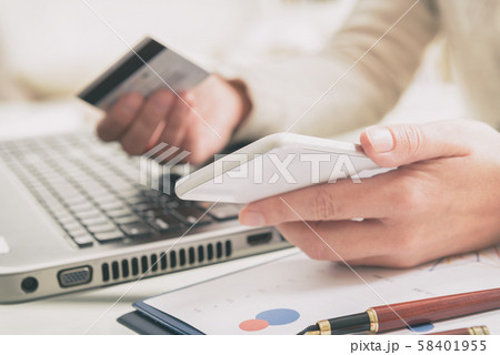 Womans hand holding credit card and smartphone 58401955