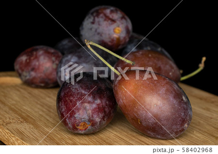 Sweet purple plum isolated on black glass 58402968