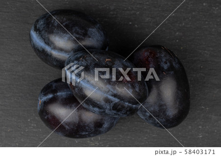 Fresh purple plum on grey stone Fresh purple plum on grey stone 58403171